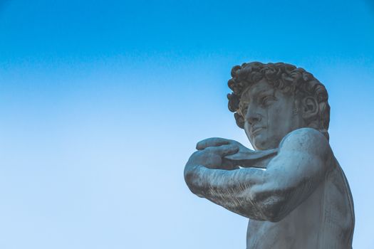 Statue of Michelangelo's David with a striking blue sky background, highlighting the artwork's details.