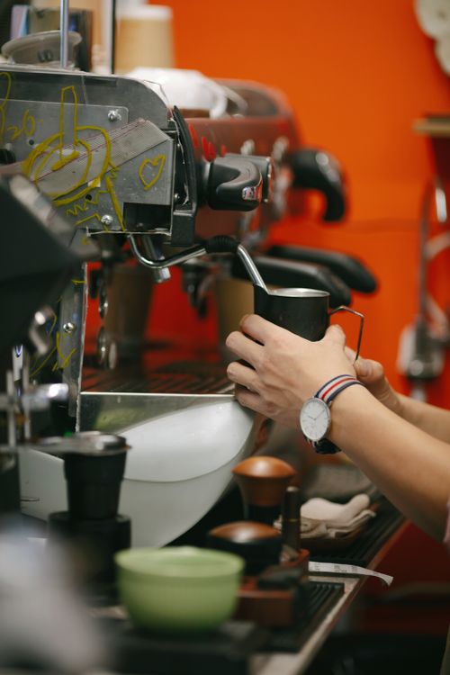 Free A barista operates a classic espresso machine in a vibrant coffee shop. Stock Photo