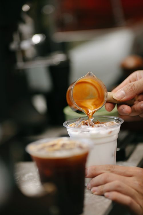 Free Close-up of espresso being poured into iced latte in a cafe setting. Stock Photo