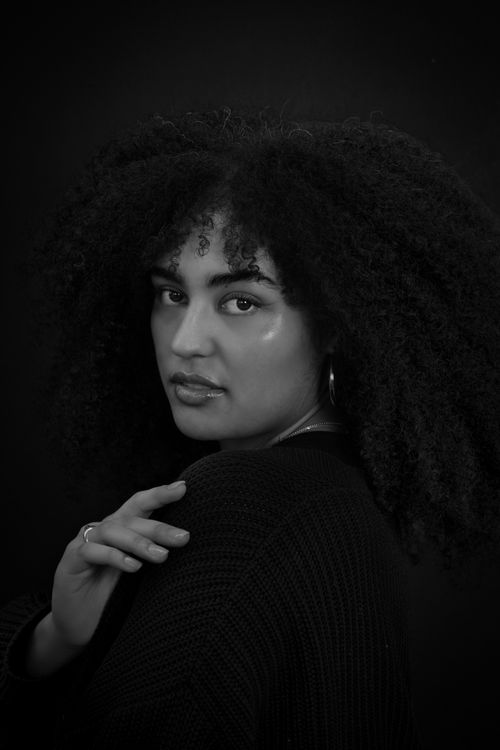Free Artistic black and white portrait of a woman with curly hair, expressing elegance and style. Stock Photo