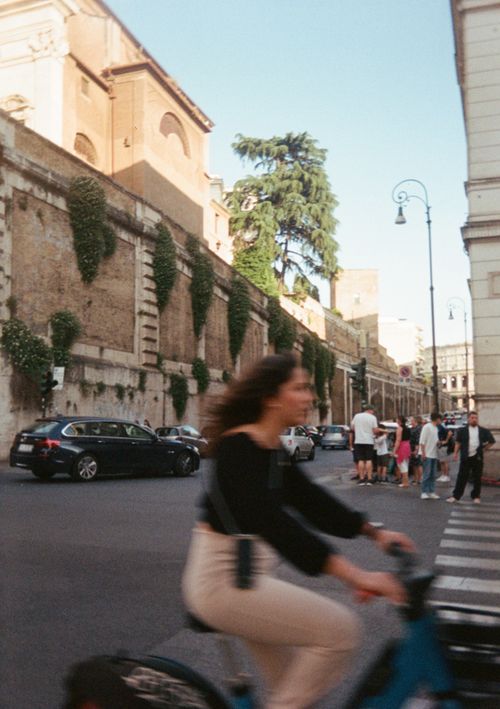 Free Street scene with a blurred cyclist on a city intersection, featuring historic architecture. Stock Photo