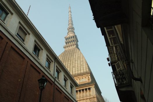 View of the iconic Mole Antonelliana tower framed by surrounding buildings in Turin, Italy.