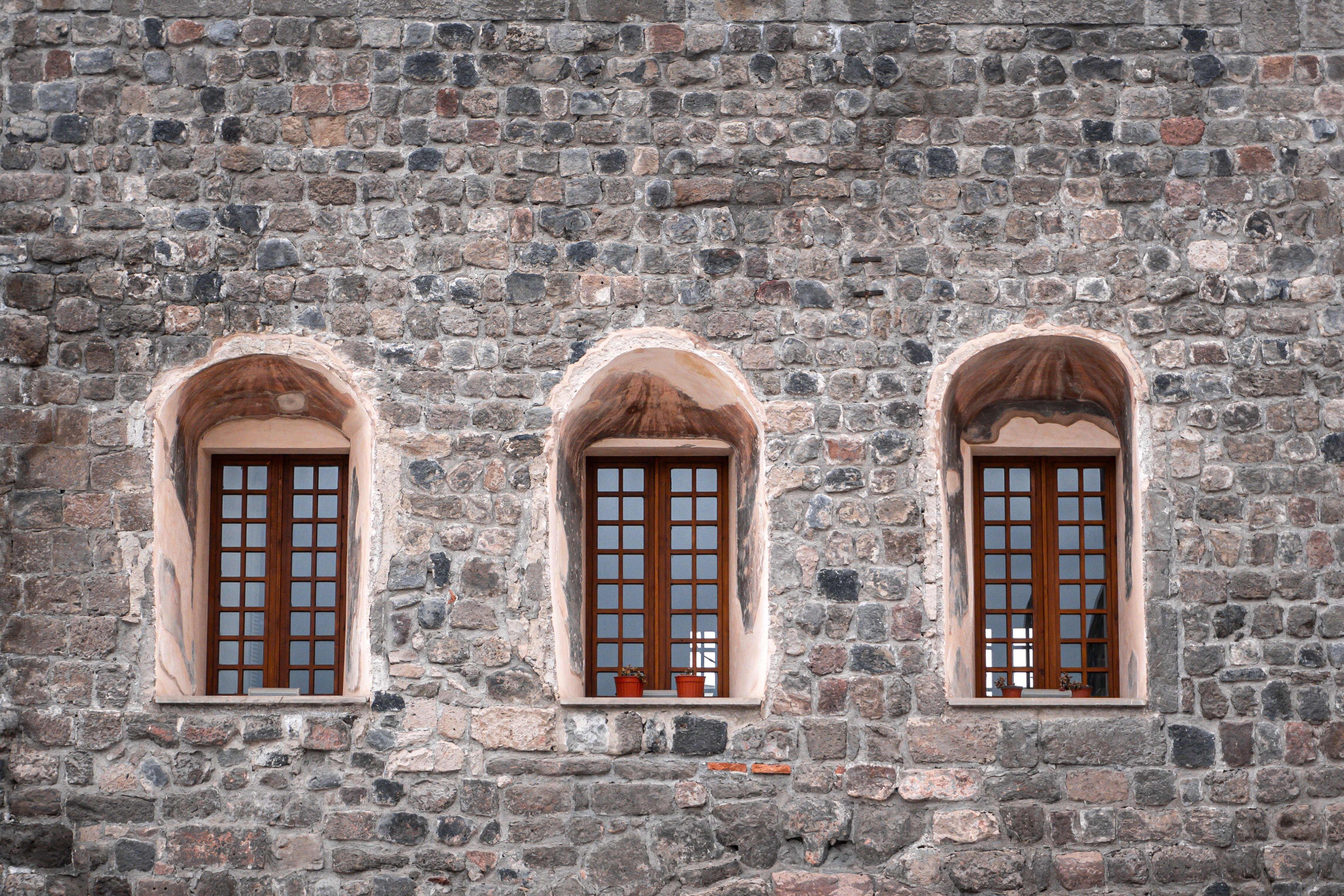 Three Arched Windows in Historic Stone Wall · Free Stock Photo