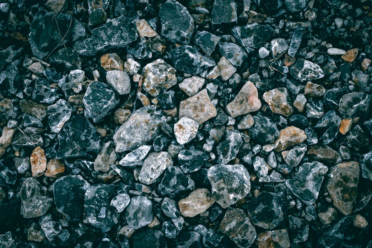 a detailed close up of textured gravel featuring various stones and ro