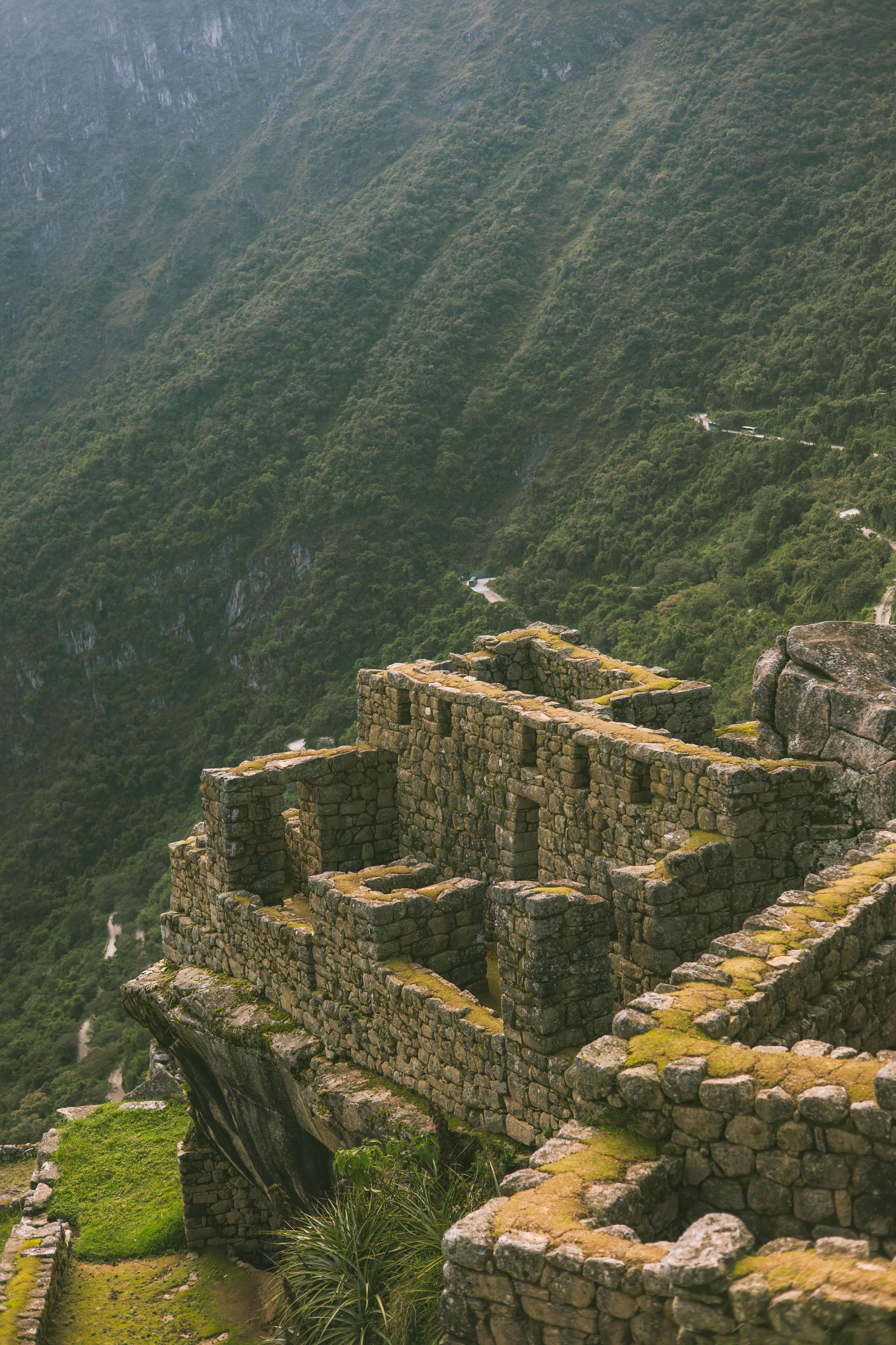 Machu Picchu stone ruins nestled in lush green mountains, showcasing ancient architecture.