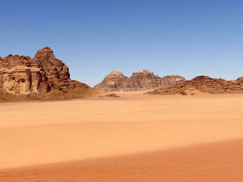 Desert formations stretching to the horizon under blue sky