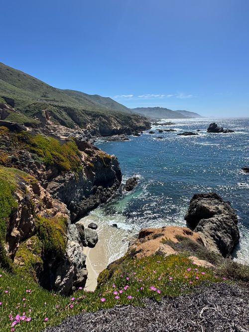 Free Breathtaking daytime view of Malibu's rugged coastline with lush greenery and clear blue waters. Stock Photo