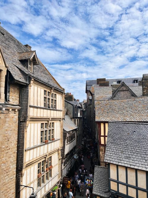 Free Scenic view of historic buildings and lively streets at Mont Saint Michel, France. Stock Photo