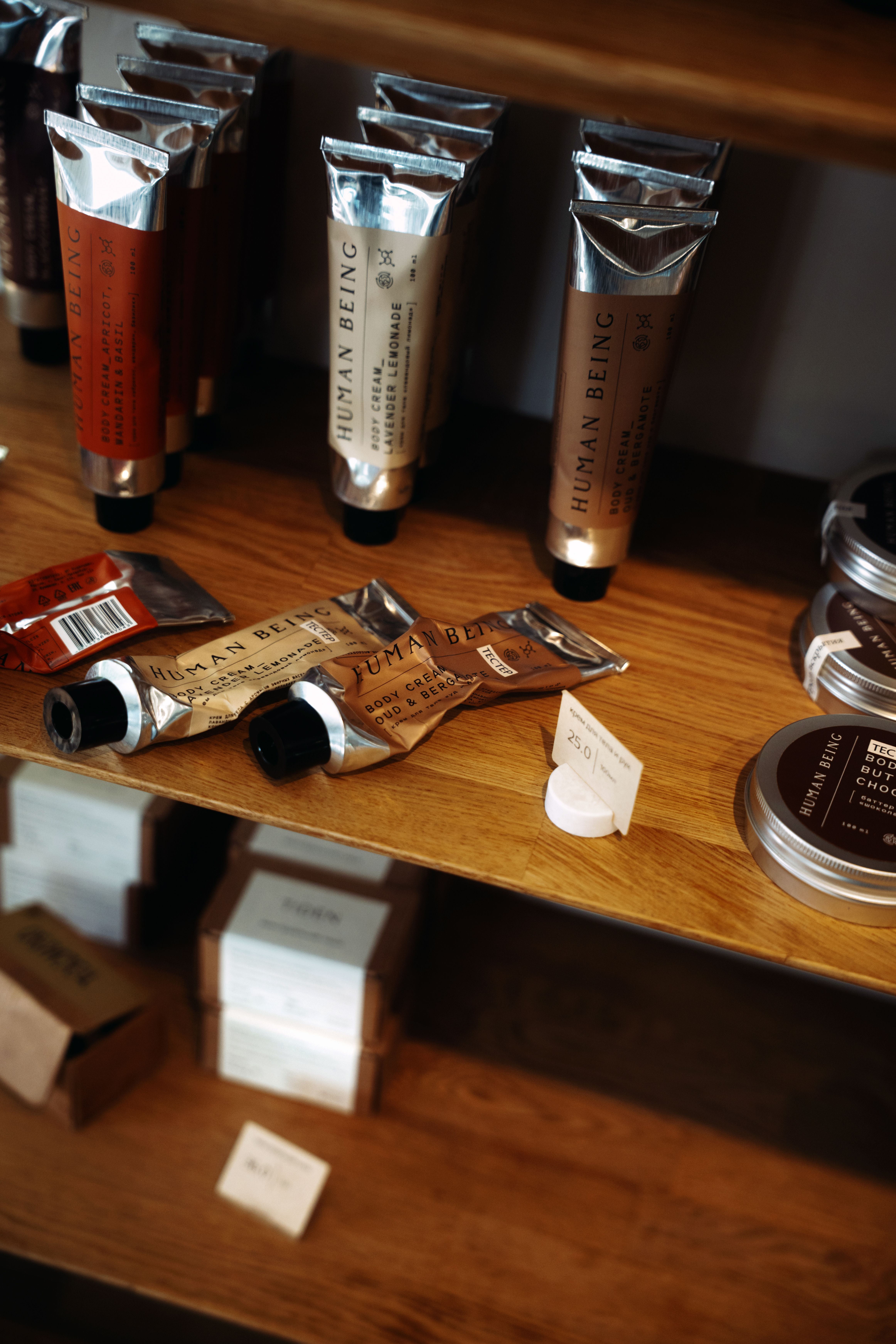 Elegant tubes and boxes of cosmetic products neatly arranged on wooden shelves.
