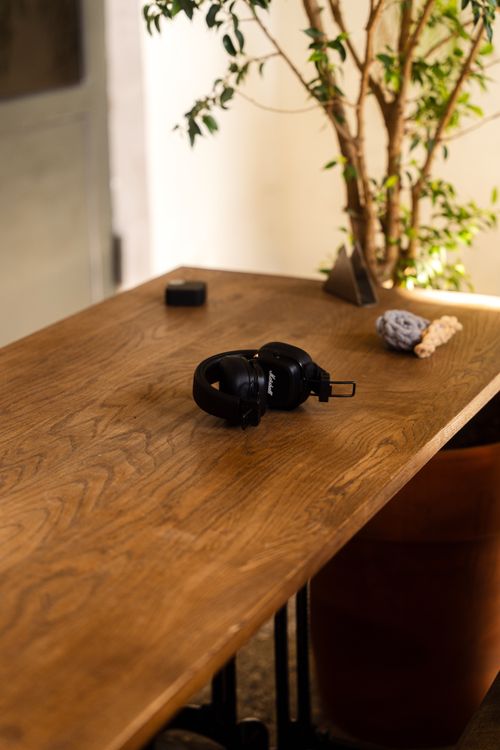 Free Wooden table with headphones and decor in minimalist indoor setting. Stock Photo