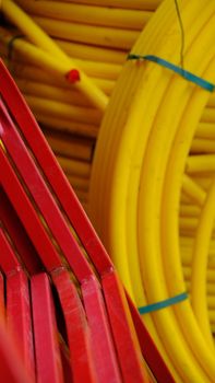 Vibrant close-up of red metal bars and yellow pipes, creating an abstract industrial pattern.