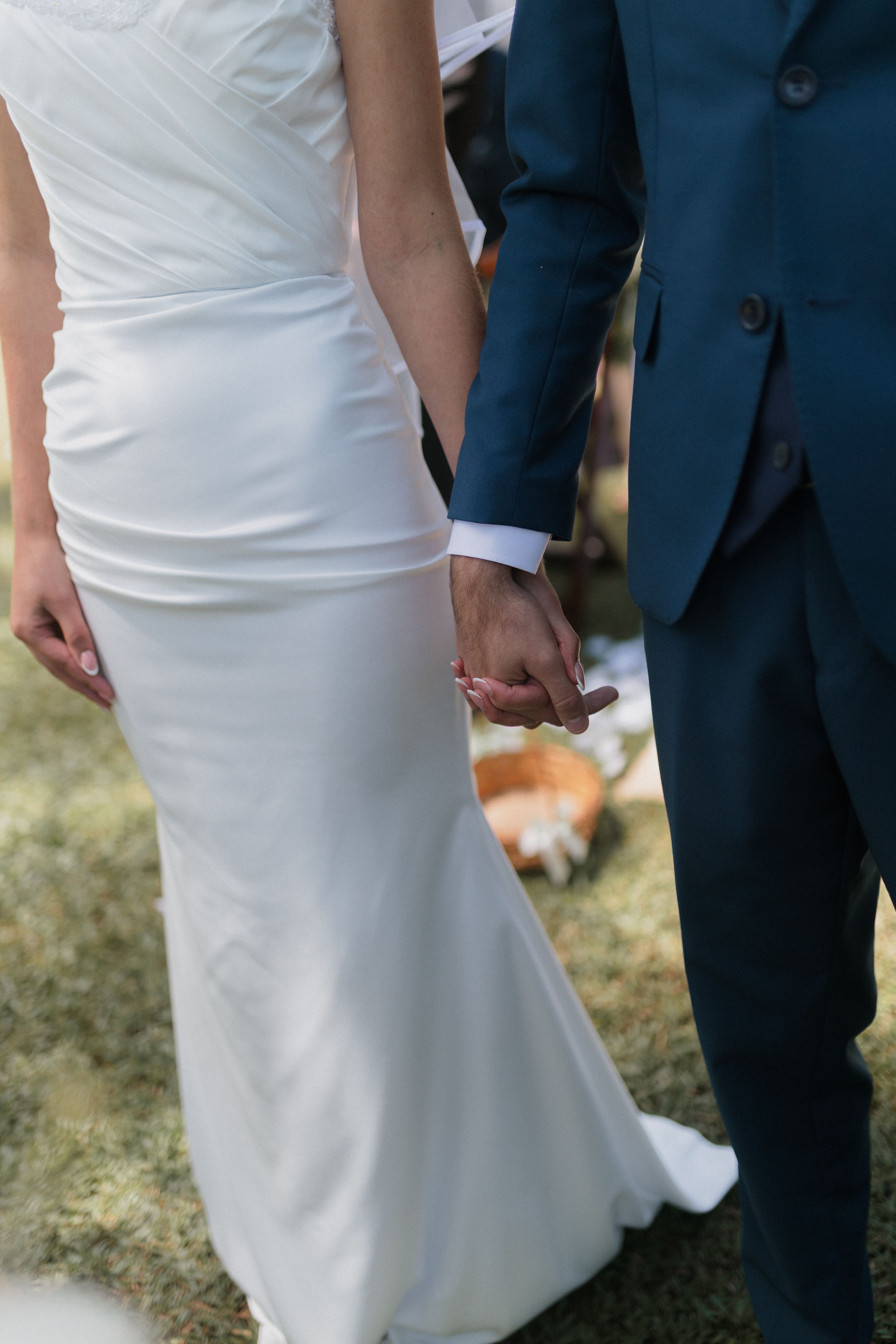 Elegant Wedding Couple Holding Hands Outdoors · Free Stock Photo
