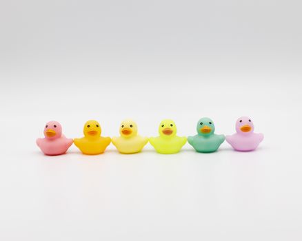 Vibrant multicolored rubber ducks in a row on a clean white background.