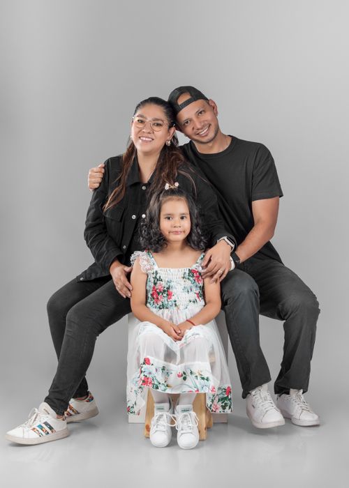 Free Smiling family with child posing in casual attire in a bright studio. Stock Photo