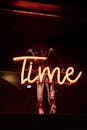 在黑暗背景下，充满活力的霓虹灯“时间”标志温暖发光，为里斯本的夜生活增添了魅力