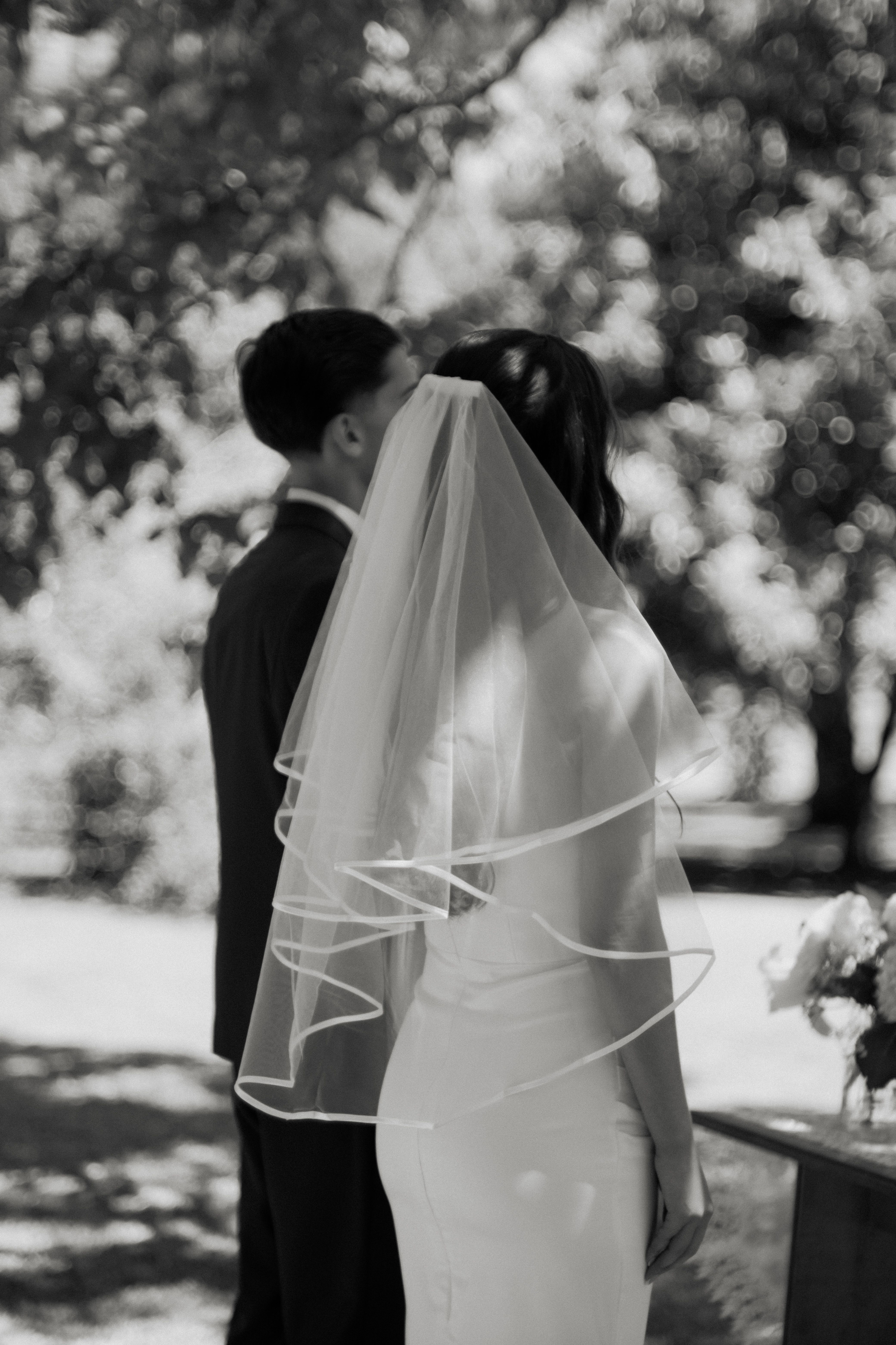 Black and White Shot of a Newlywed Couple Kissing · Free Stock Photo