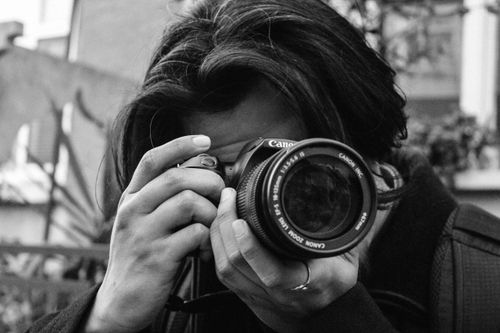 Free A black and white photo of a photographer capturing an image outdoors. Stock Photo