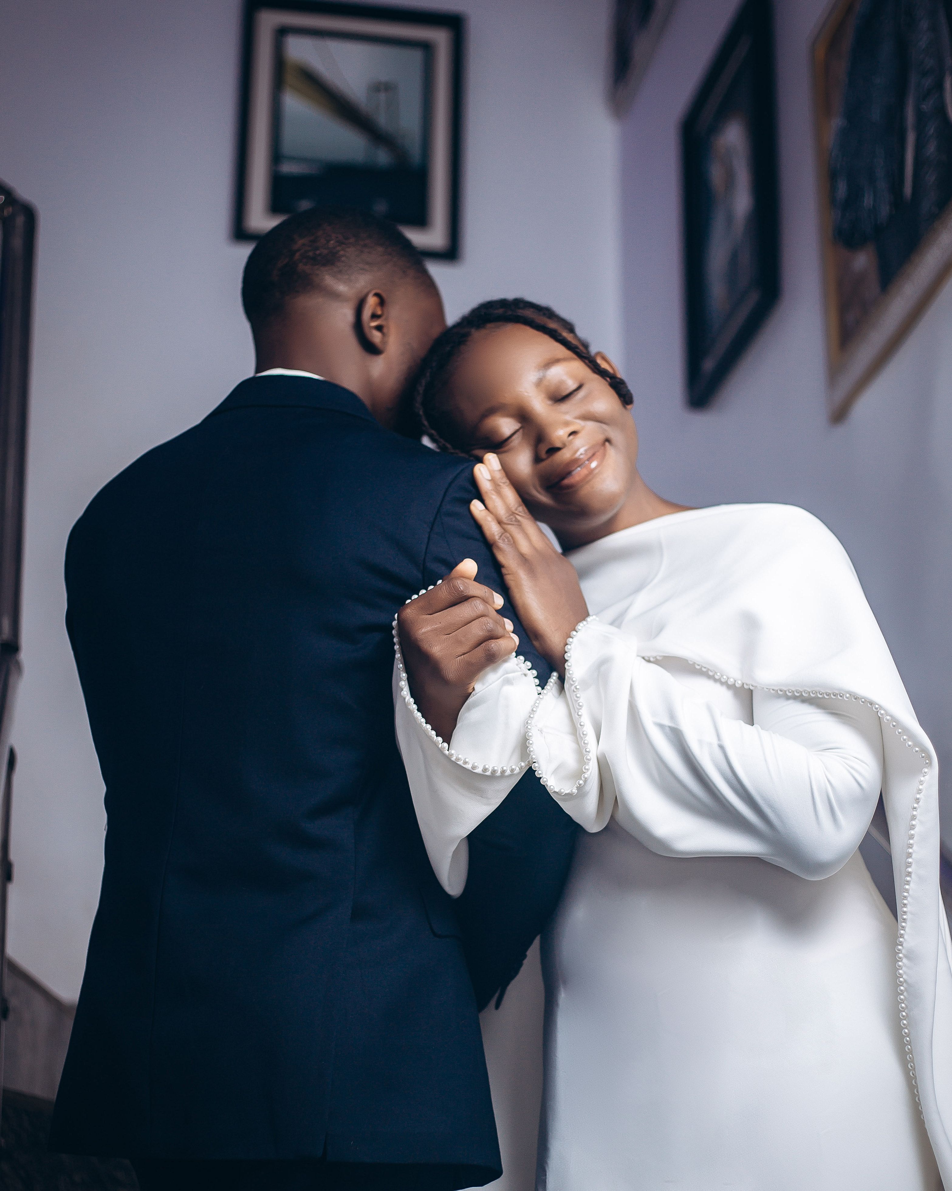 Elegant wedding couple in Jos, Nigeria, sharing a tender embrace indoors.