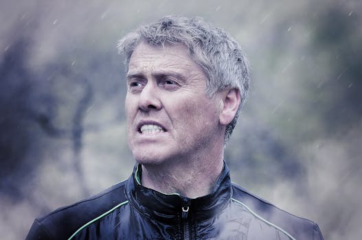 Man in Blue and Black Full Zip Jacket Standing during Daytime