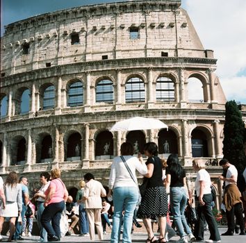 Visitors gather at the iconic Colosseum in Rome, capturing its historic charm on a sunny day.