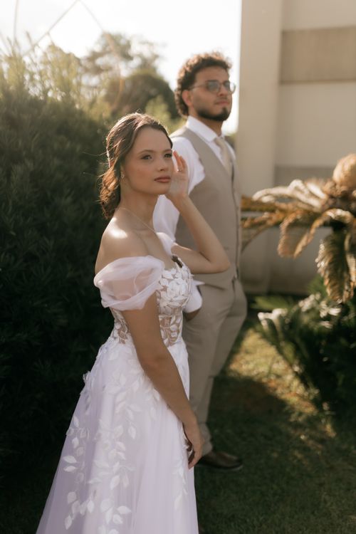 Free Beautiful bride in white gown with groom outdoors in sunlight. Stock Photo