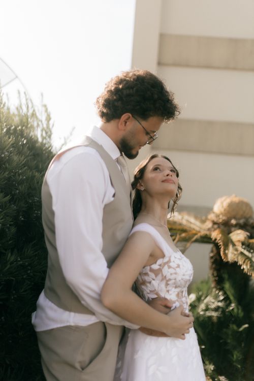 Free Bride and groom embrace outdoors in soft, warm sunlight on their wedding day. Stock Photo