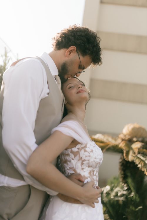 Free A loving couple embraces on their wedding day outdoors, captured in soft and warm light. Stock Photo