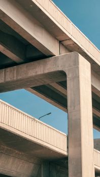 A towering concrete overpass structure with a clear blue sky background, showcasing modern architecture.