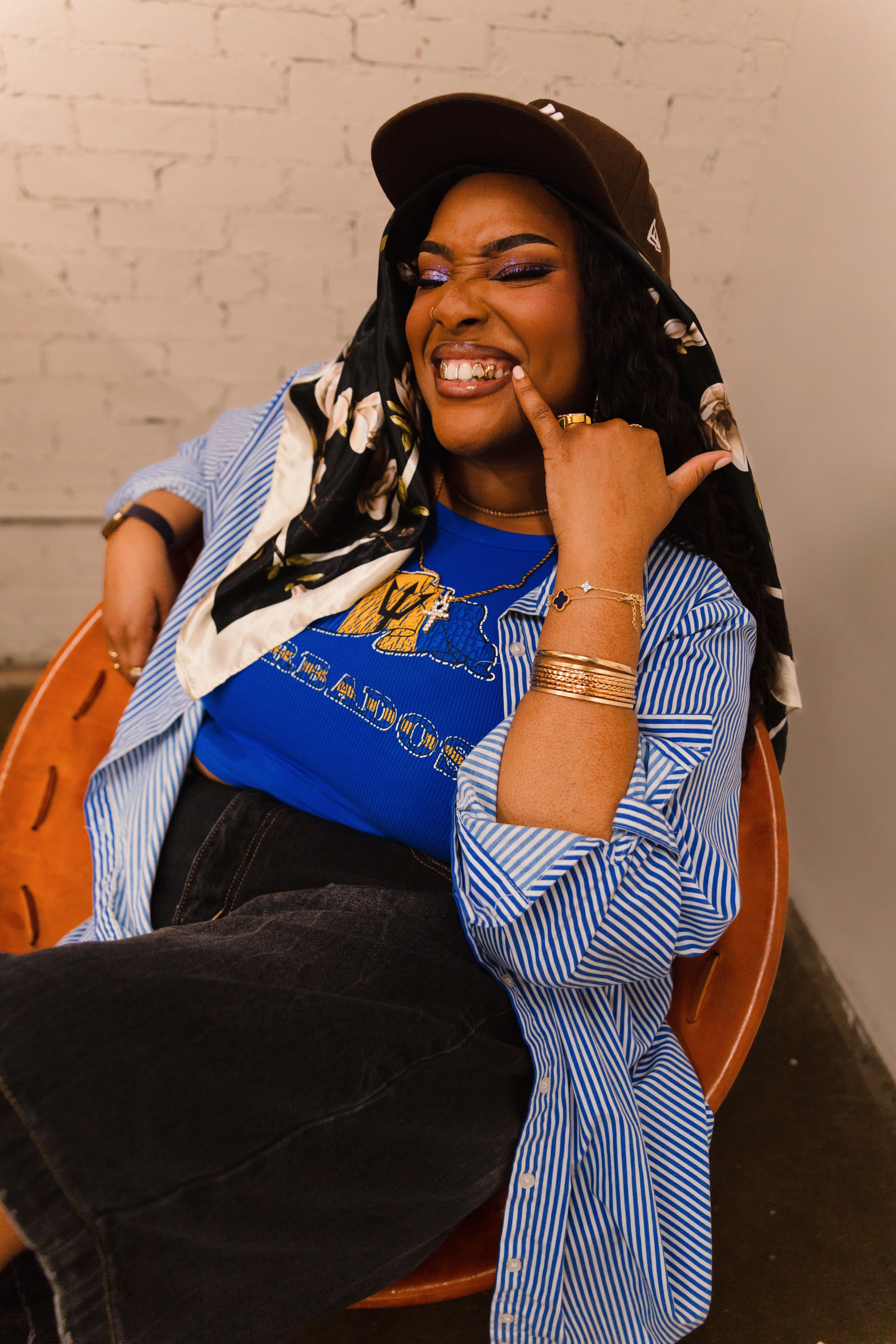 Chic woman smiling and relaxing in a modern chair, wearing trendy fashion.