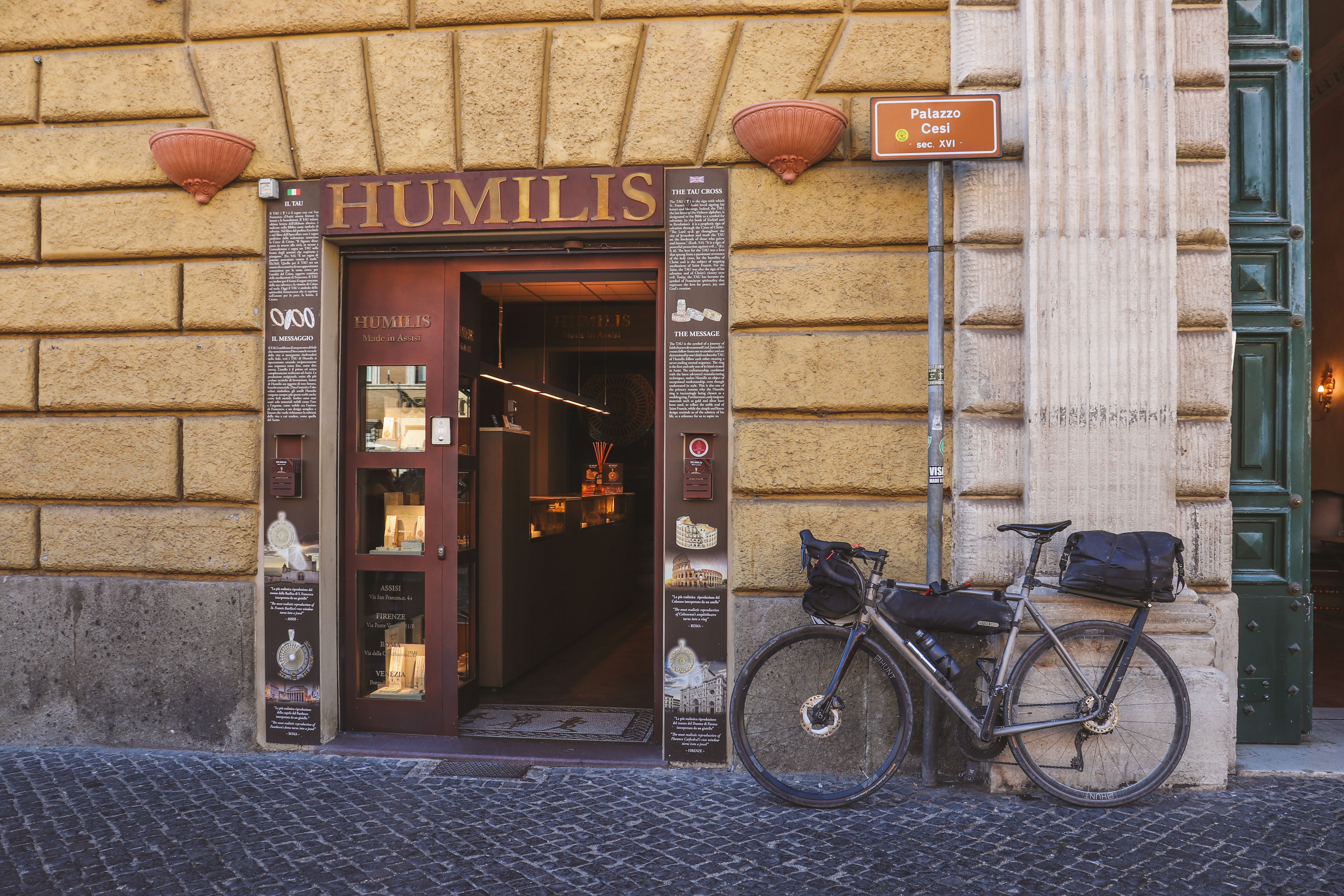 Charming boutique entrance with bicycle in historic Vatican City, capturing classic Italian street style.