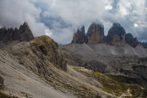 Free Dramatic view of Tre Cime di Lavaredo peaks under cloudy skies in the Italian Alps. Stock Photo