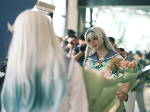 Free A cosplayer dressed in anime costume holding flowers, captured at an indoor event. Stock Photo
