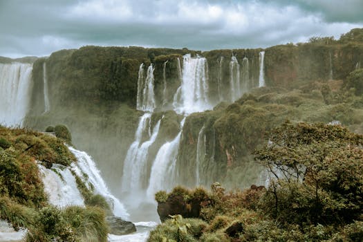 Breathtaking view of Iguazu Falls in Brazil, surrounded by vibrant rainforest and mist.