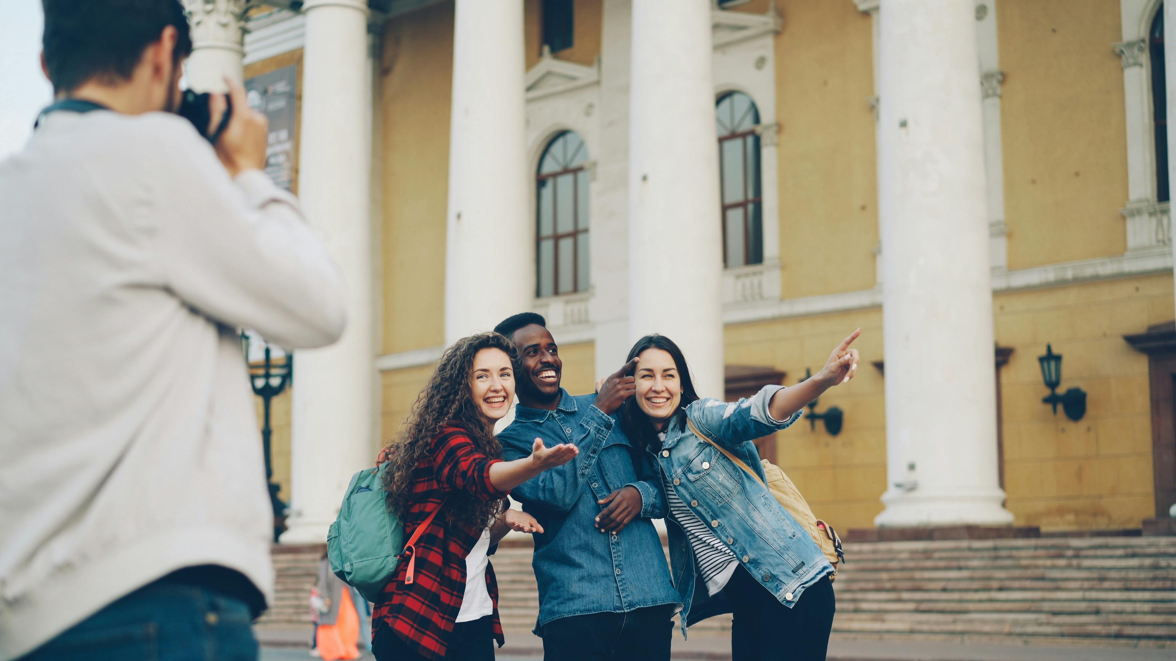 Three friends posing for a photo near a historic building with columns.