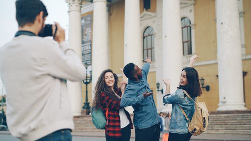 Free Group of friends posing outdoors in front of historic building with columns. Stock Photo