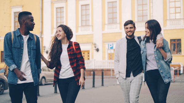 Four friends walking together along a city street &mdash; How to Plan a Group Itinerary