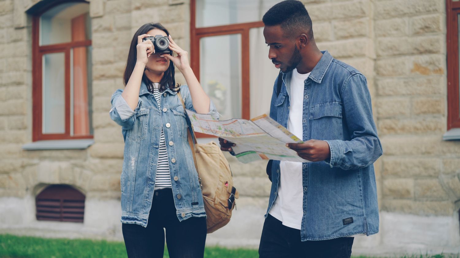 Young tourists exploring a city with a map and camera
