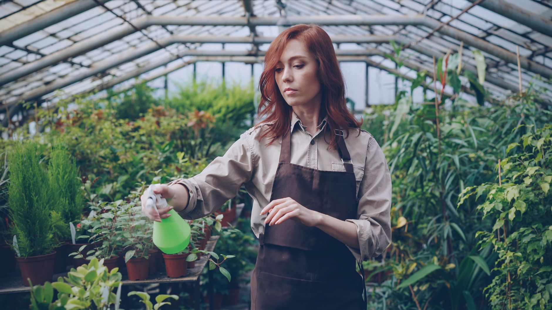 woman checking automated timer on outdoor garden irrigation system morning