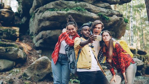 Free Group of friends taking a selfie in a forest setting. Joyful moments in nature. Stock Photo