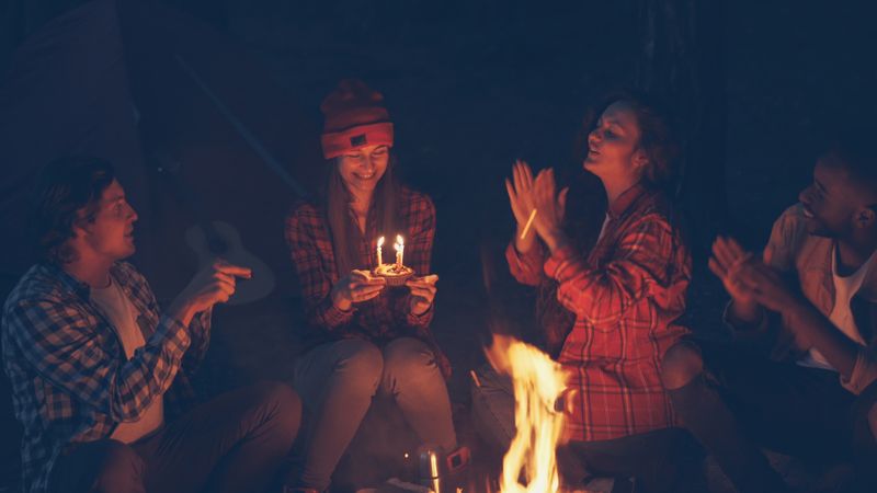 Friends celebrating around a campfire at night