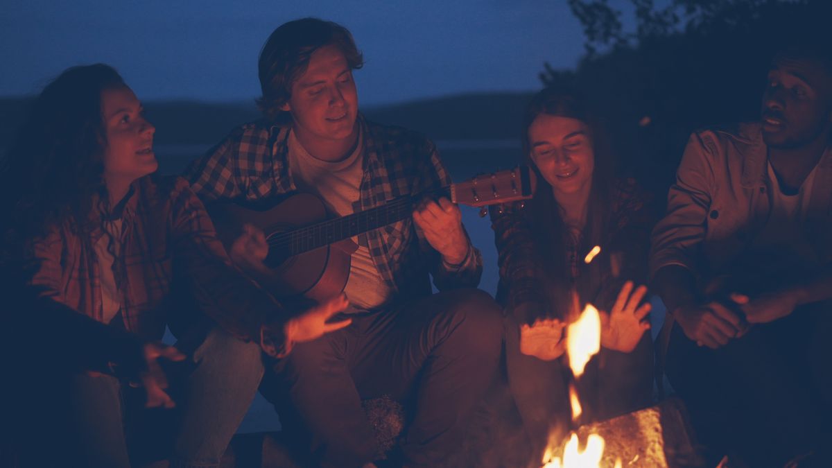 Friends gathered around an evening campfire