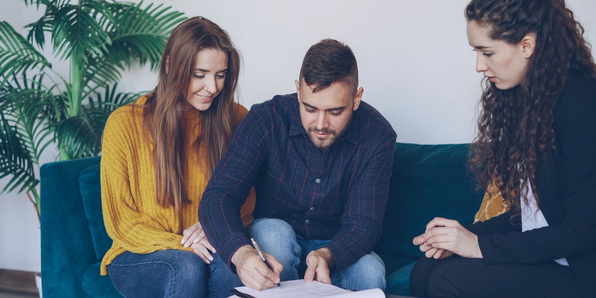 A young couple signing an agreement with an advisor