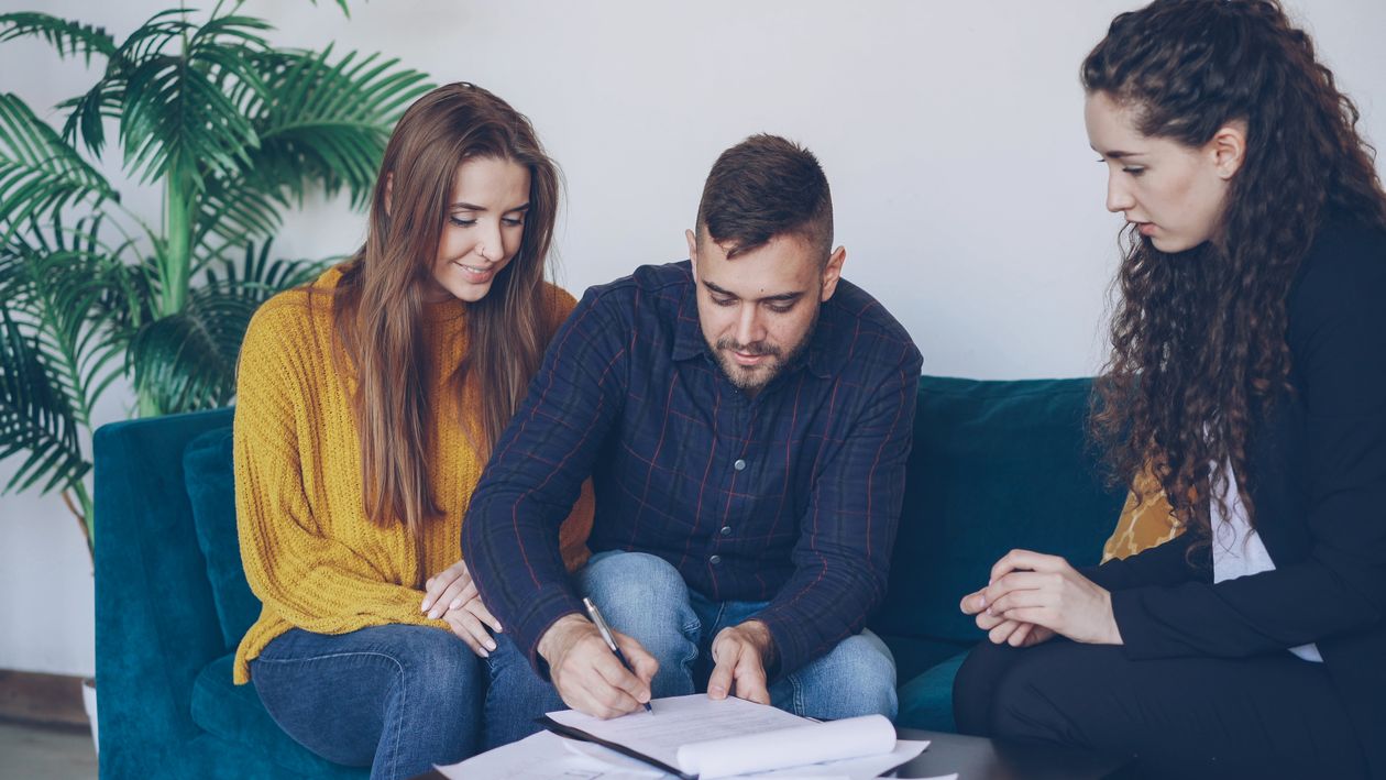 Financial Advisor Edinburgh: How to Choose the Right Adviser for Your Goals 2 Couple signing financial planning documents with an adviser