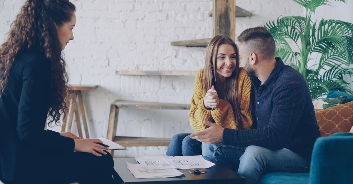 Mortgage broker reviewing amortization, term and pre-approval paperwork with clients at a Toronto office desk