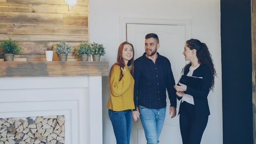 Free Young couple meeting with real estate agent inside cozy home, exploring purchase options. Stock Photo