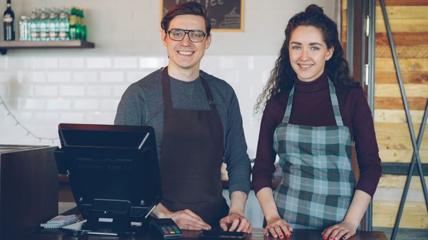 Cafe staff smiling at the counter, ready to assist customers.