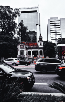 A dynamic urban scene featuring bustling traffic in front of a historic building and modern skyscrapers.