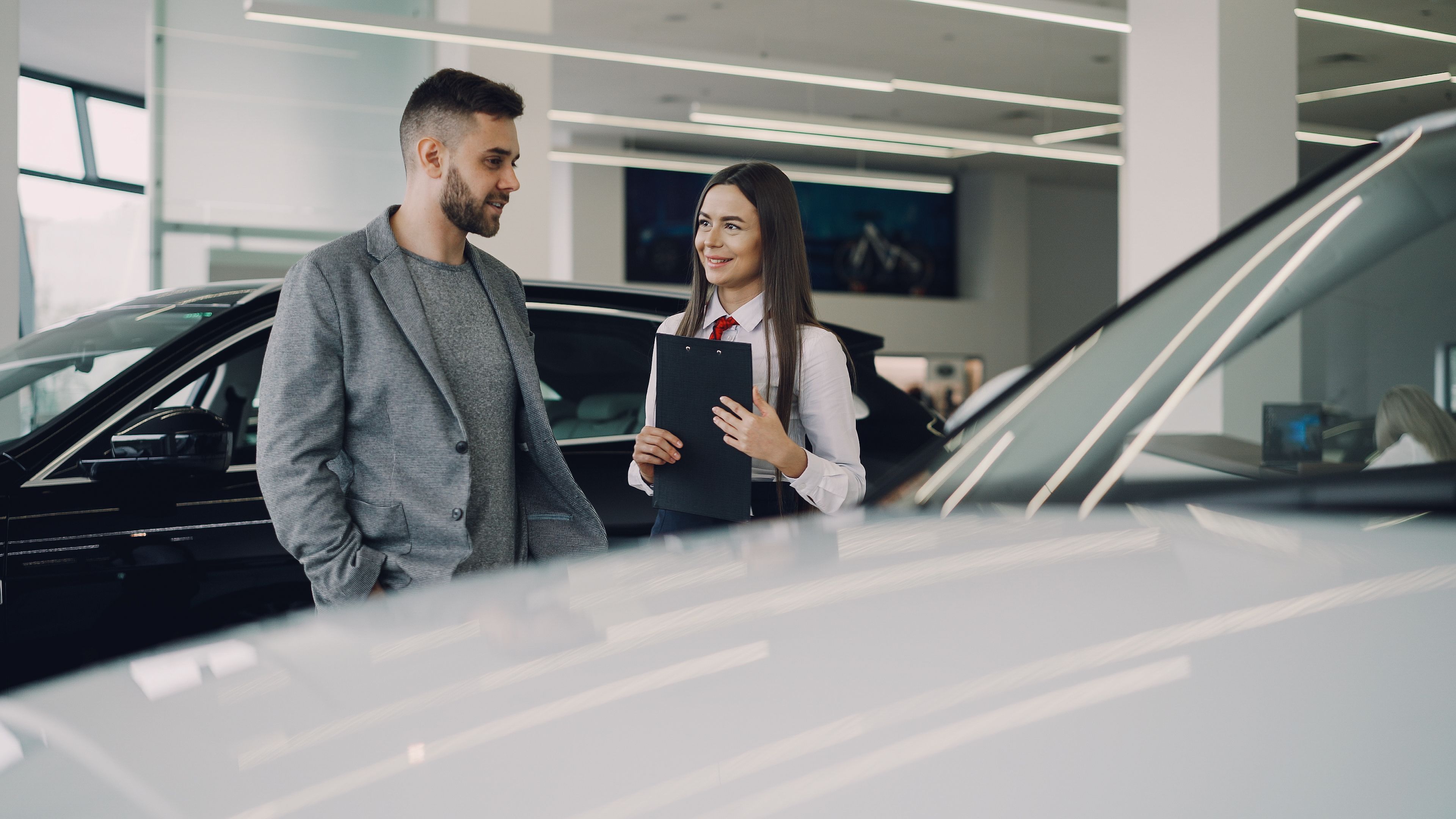 A conversation on the floor of a car showroom