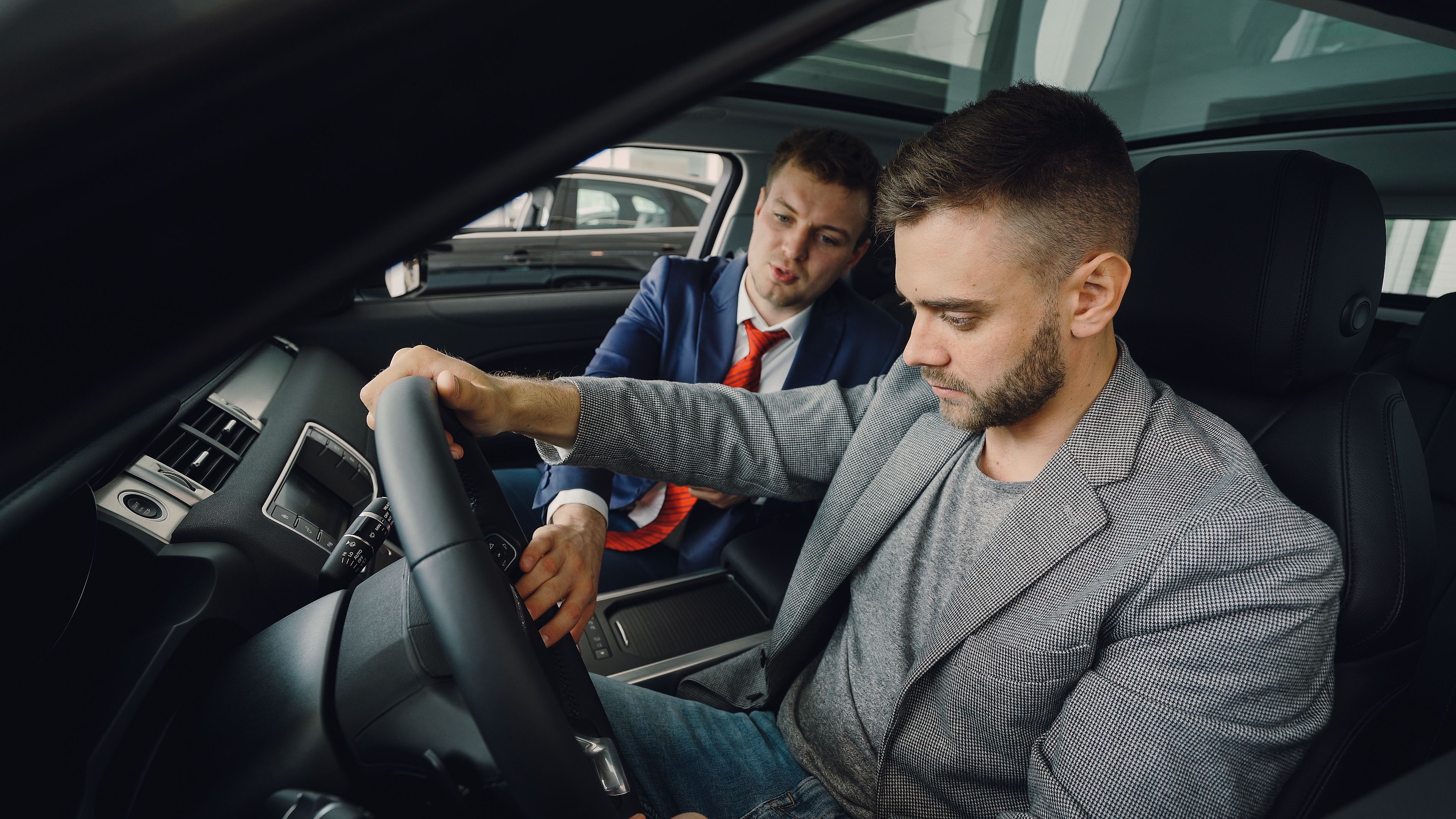 Vendedor e comprador avaliando um carro usado durante uma negociação presencial