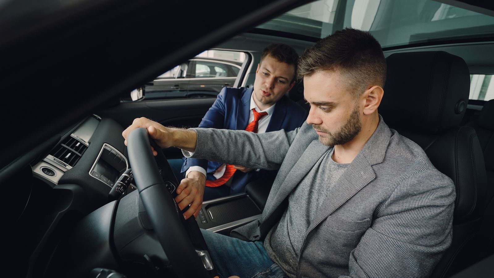Vendedor e comprador avaliando um carro usado durante uma negociação presencial